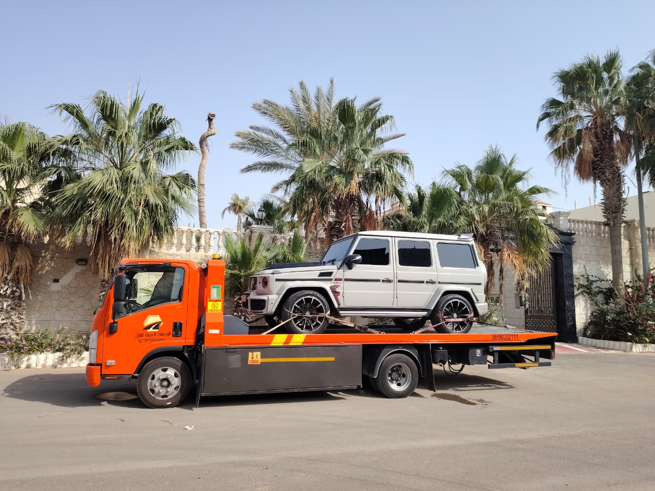 سطحة احترافية تنقل سيارة فاخرة أمام فيلا سكنية